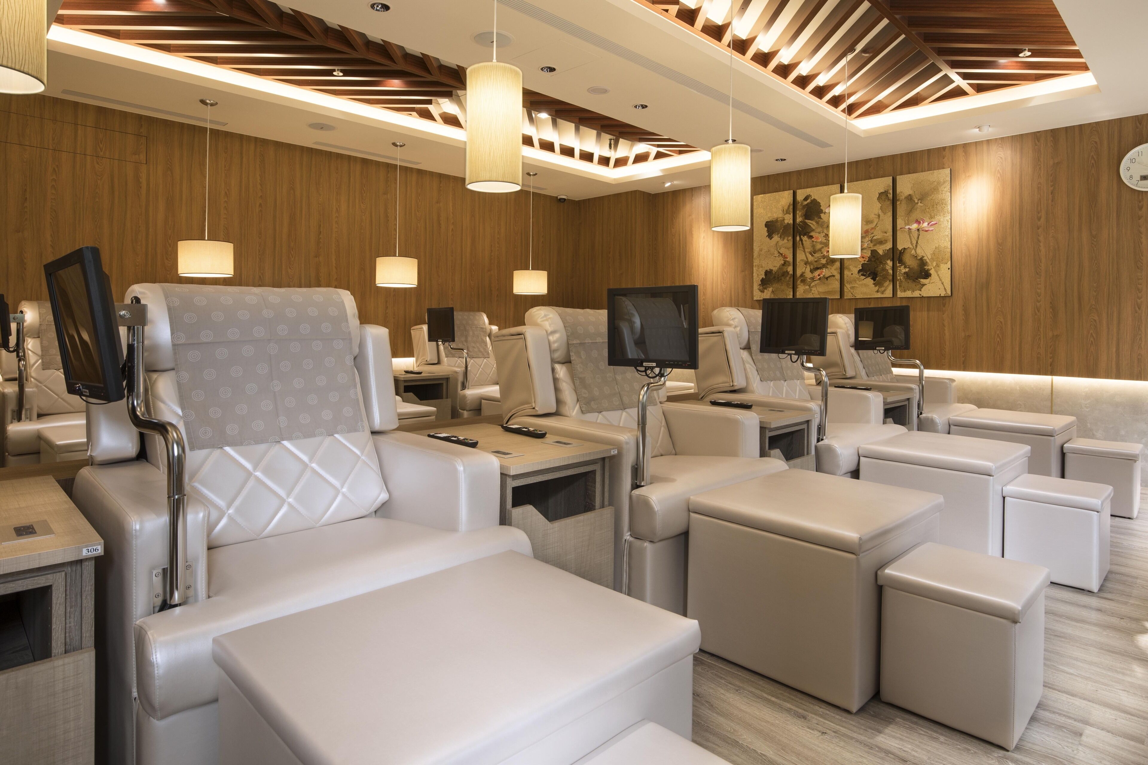 A modern hotel room with multiple reclining chairs, a flat-screen TV, and ambient lighting.