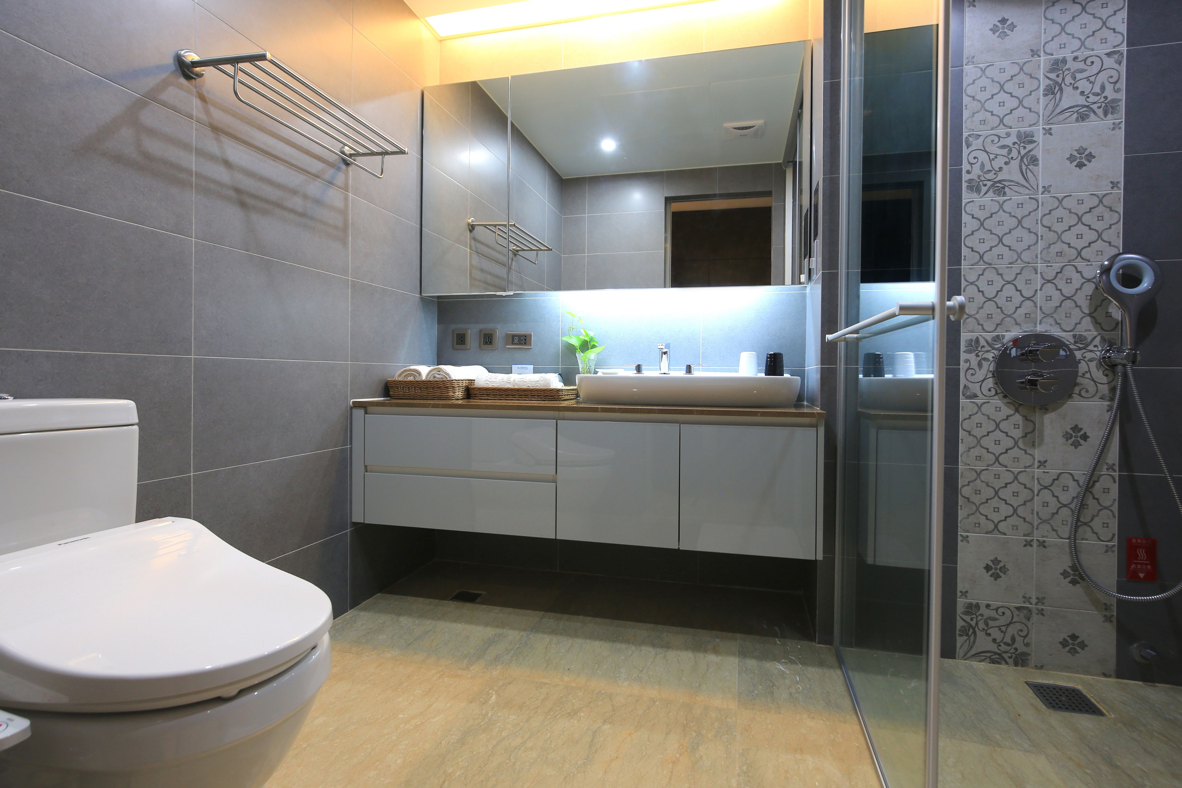 Une salle de bain moderne équipée de toilettes, d’un lavabo et d’une douche.