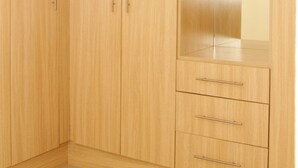 Un armario de madera con dos puertas y un espejo.