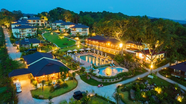 Un resort con varias edificaciones, una piscina y jardines bien cuidados.