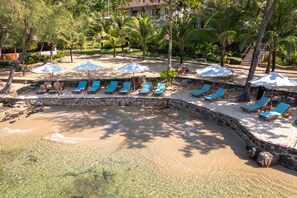 Playa privada, sombrillas, toallas de playa y bar en la playa 