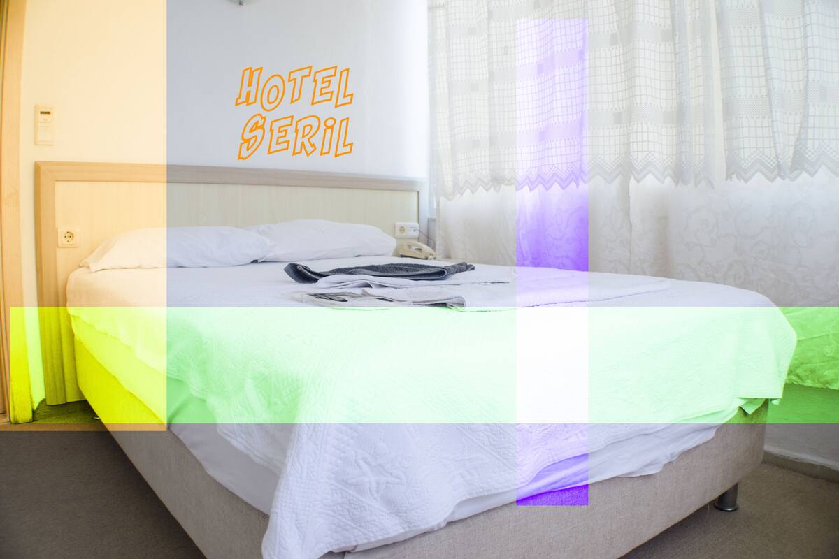 Quarto de hotel com cama, mesa de cabeceira e janela com cortinas.