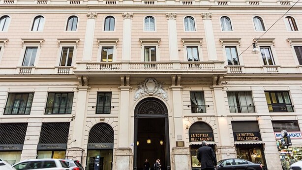 A multi-story building with a central entrance, balconies, and signage for 'La Bottega dell'Argento'. - Queen Palace Suites (Rome)