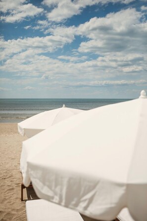 Privatstrand, weißer Sandstrand, Liegestühle, Sonnenschirme