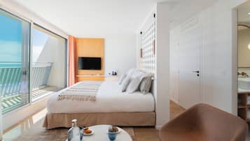 Une chambre d’hôtel moderne dotée d’un balcon, d’un lit, d’une télévision et d’un coin salon.