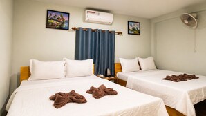 A hotel room with two beds, a ceiling fan, an air conditioning unit, and two framed pictures on the wall. - The Cliff Hostel (Koh Rong Sanloem)