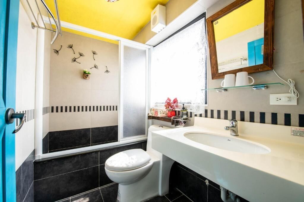A bathroom with a toilet, sink, and shower area.