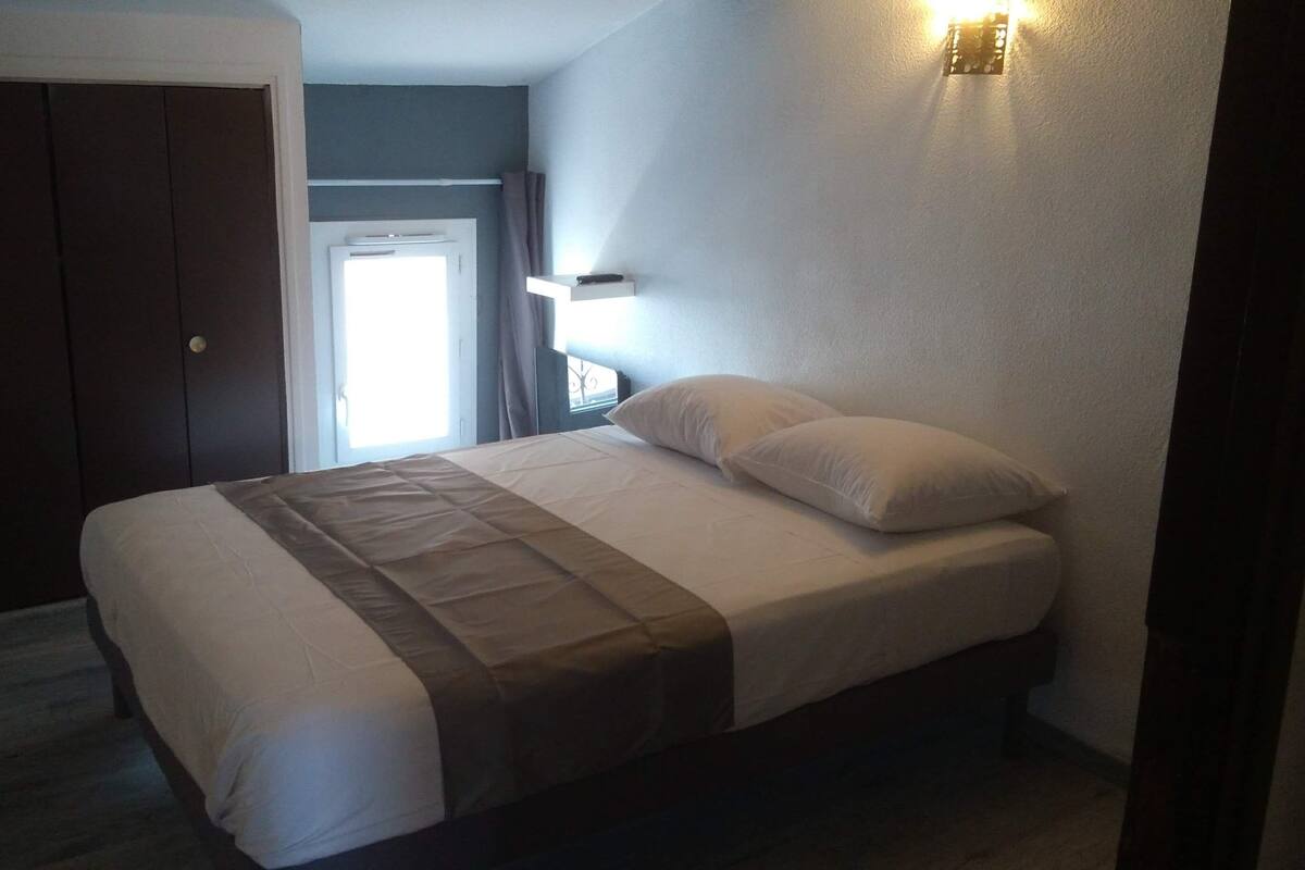 Un dormitorio con cama, puerta y ventana.