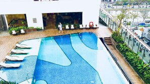 A rooftop swimming pool with multiple lanes, surrounded by lounge chairs and potted plants. - Herla Central Saigon (Ho Chi Minh City)