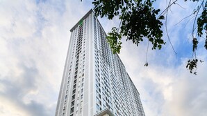 A tall, modern building with a prominent entrance and a sign indicating it is a residence. - TeeUP Home (Ho Chi Minh City)
