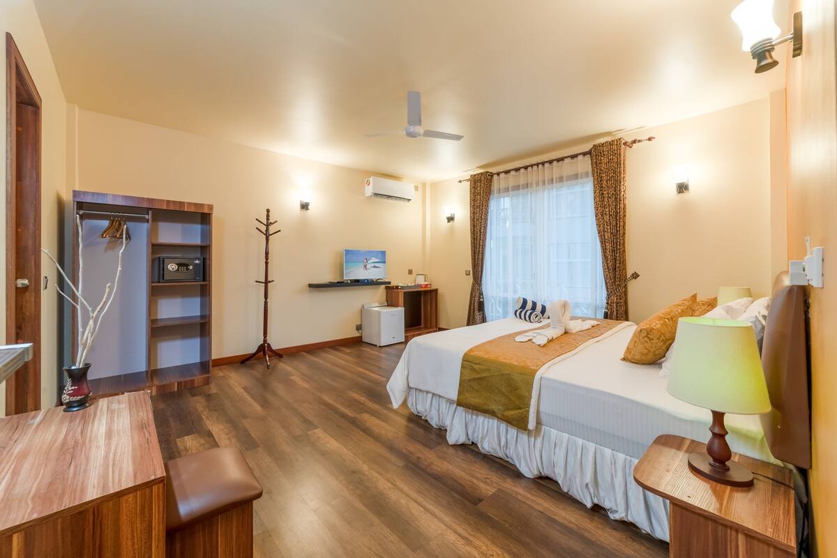 Une chambre d’hôtel comprenant un lit, une table de chevet, un bureau et une armoire.