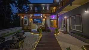 A hotel reception area with a sign, a wooden deck, and a view of the surrounding landscape.