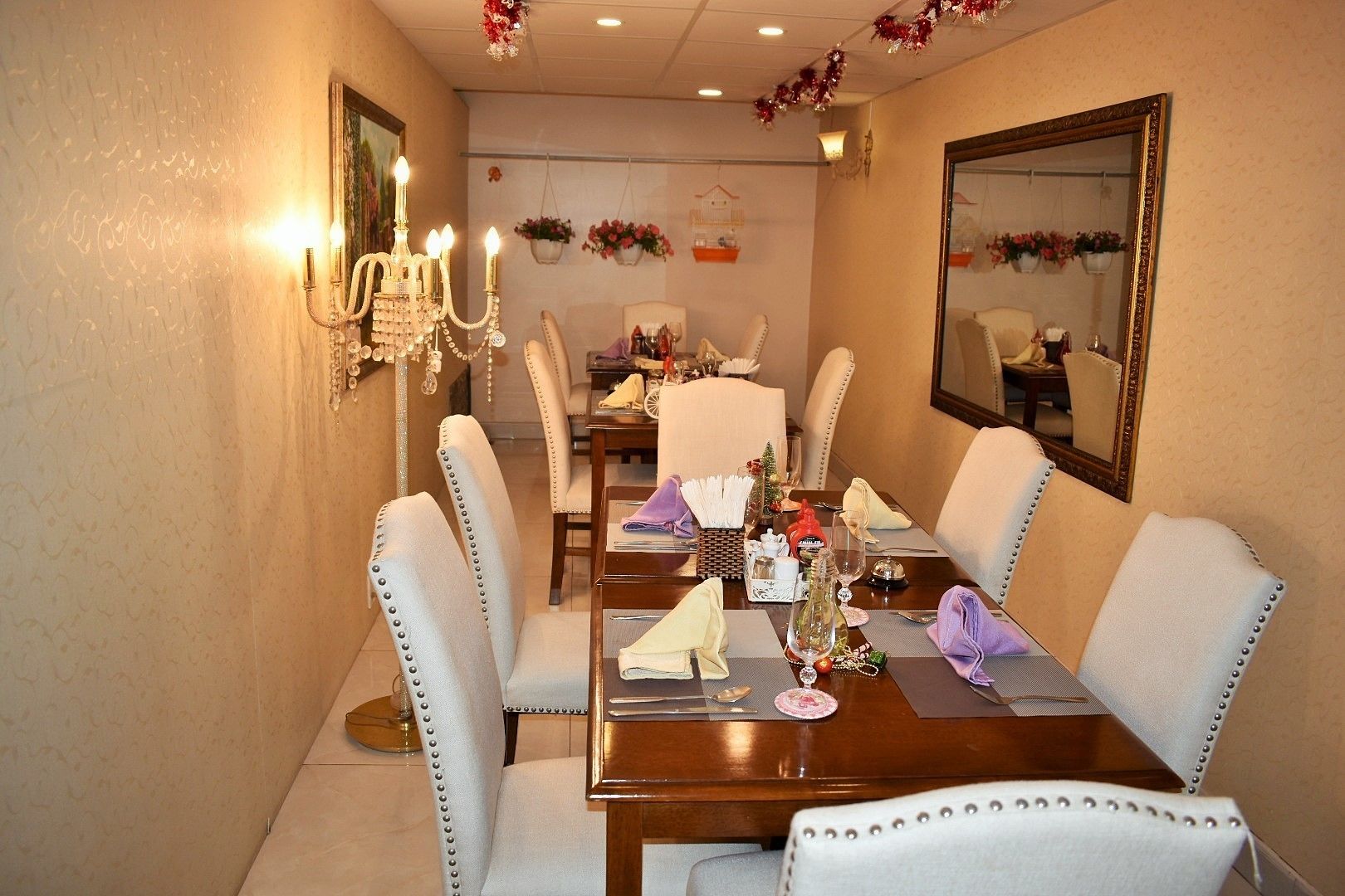 A dining room with a wooden table set for four, surrounded by upholstered chairs with metal studs.