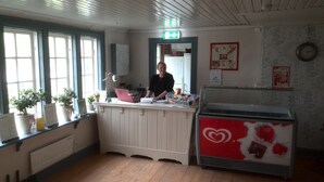 Une cuisine avec un plancher en bois, un comptoir blanc et un réfrigérateur orné d’un motif en forme de cœur.