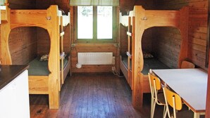 Une cabine équipée de lits superposés, d’une table, de chaises, d’une fenêtre avec vue et d’un radiateur.