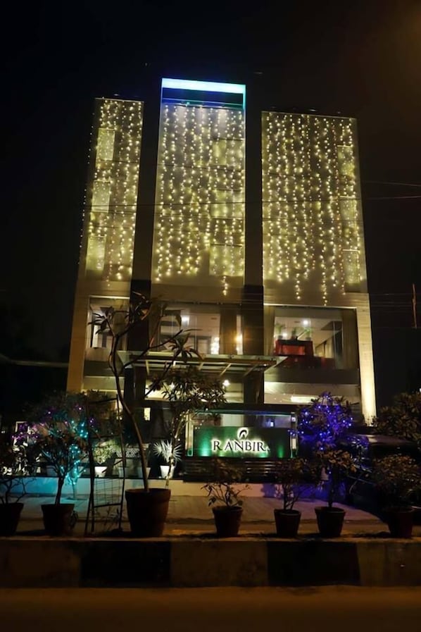 Vista frontal de la propiedad por la tarde o noche