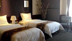 Habitación de hotel con dos camas, un escritorio y una silla.