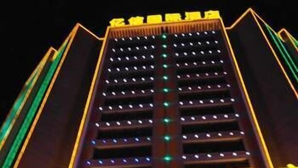 Un hotel de diseño moderno, con un llamativo letrero con luces en la entrada.