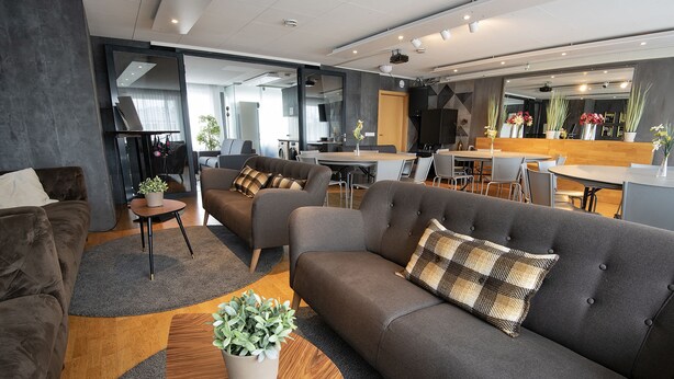 A modern living area with sofas, a coffee table, and a dining table. - B14 Hostel (Reykjavik)
