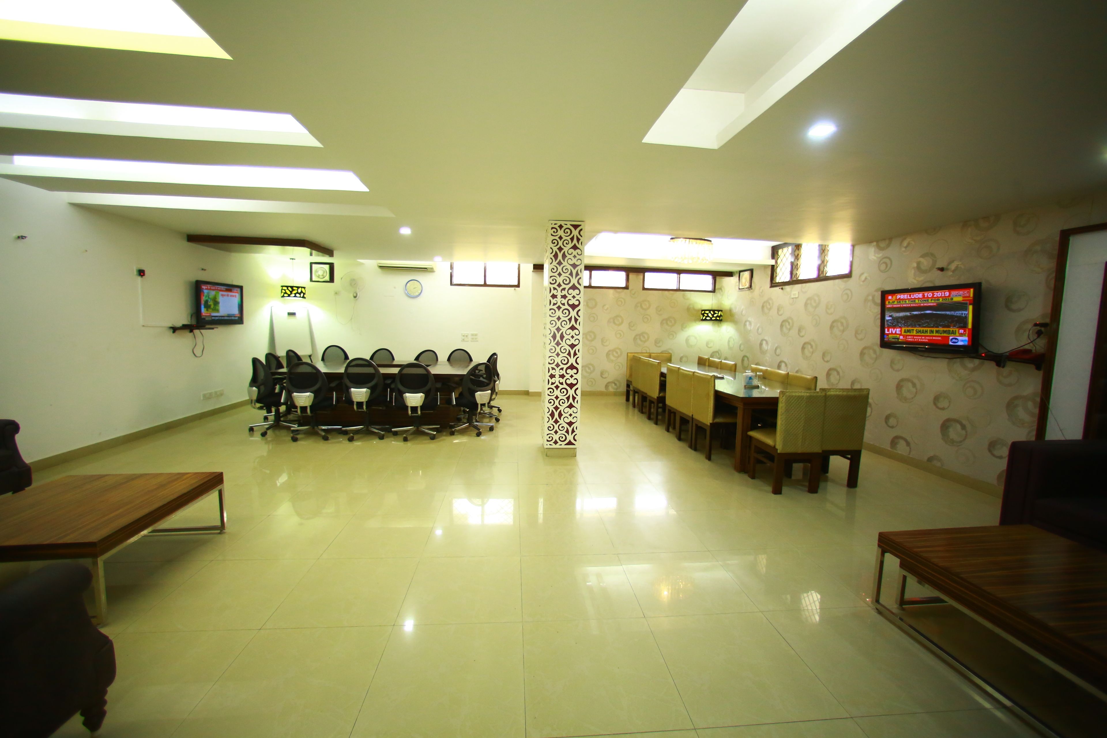 A conference room with a long table, chairs, and a TV screen.