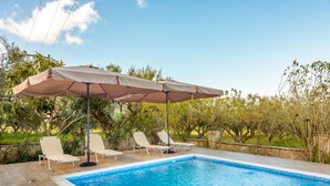 A swimming pool with lounge chairs and an umbrella. - Zante 5 bedroom Villa with private pool and basketball court (Zakynthos)