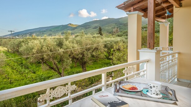 A balcony with a view of green hills and a clear sky. - Zante 5 bedroom Villa with private pool and basketball court (Zakynthos)
