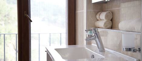 A bathroom with a sink, mirror, and towel rack.