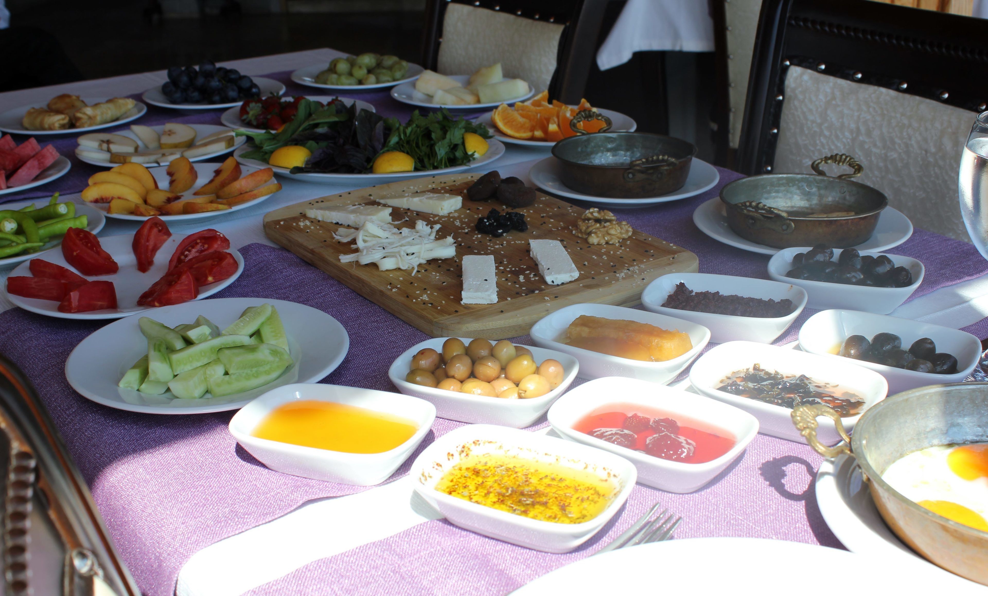 A table with various food items and dishes, including fruits, vegetables, and condiments.