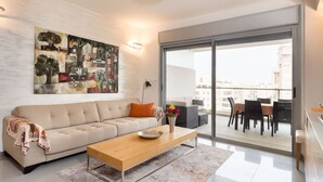 Uma sala de estar moderna com um sofá, mesa de centro e obras de arte na parede.