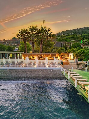 A beachfront resort with a pool area, lounge chairs, and umbrellas. - Assos Kayalar Blue Beach Hotel (Ayvacik)