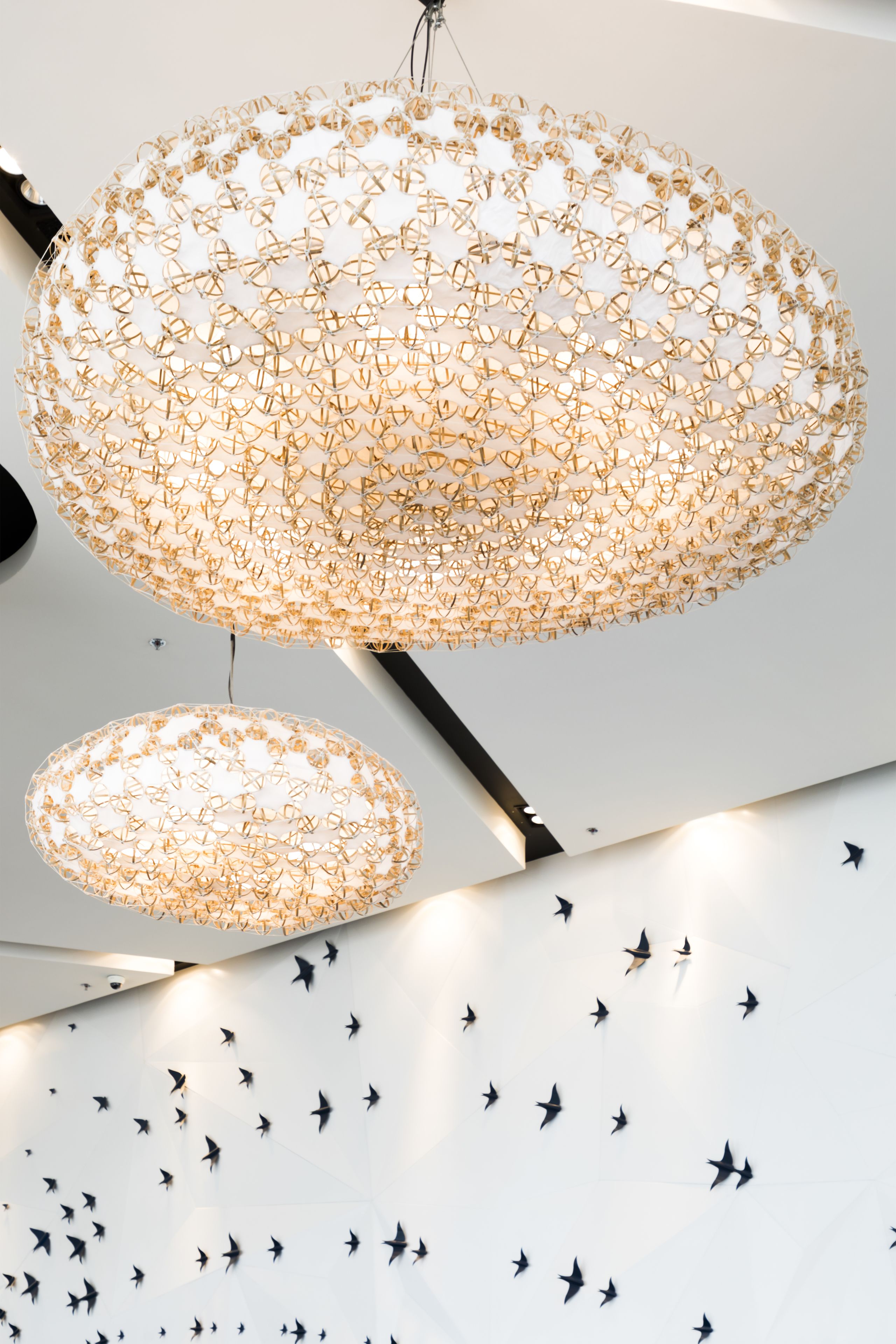 A chandelier with a geometric design and a wall with a star pattern.