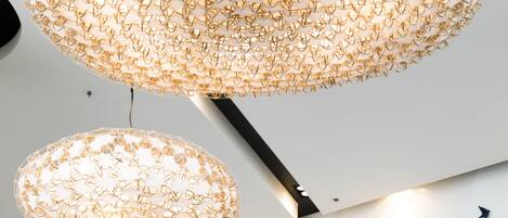 A chandelier with a geometric design and a wall with a star pattern.