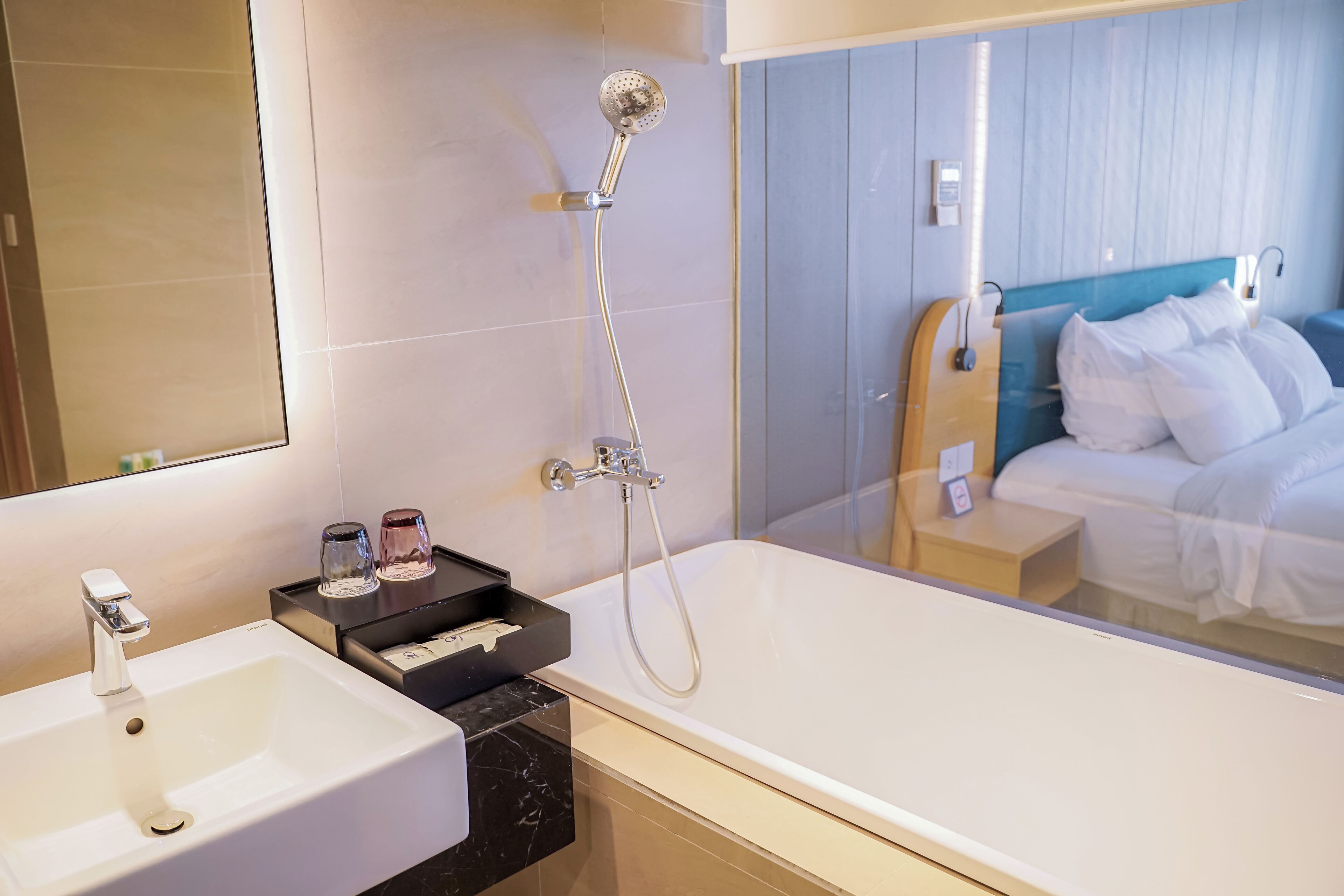 A modern bathroom with a large bathtub, a sink, and a mirror.