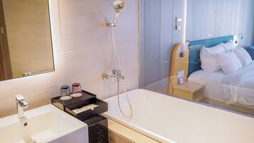 A modern bathroom with a large bathtub, a sink, and a mirror.