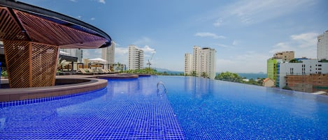 Una piscina al aire libre, sillones reclinables de piscina