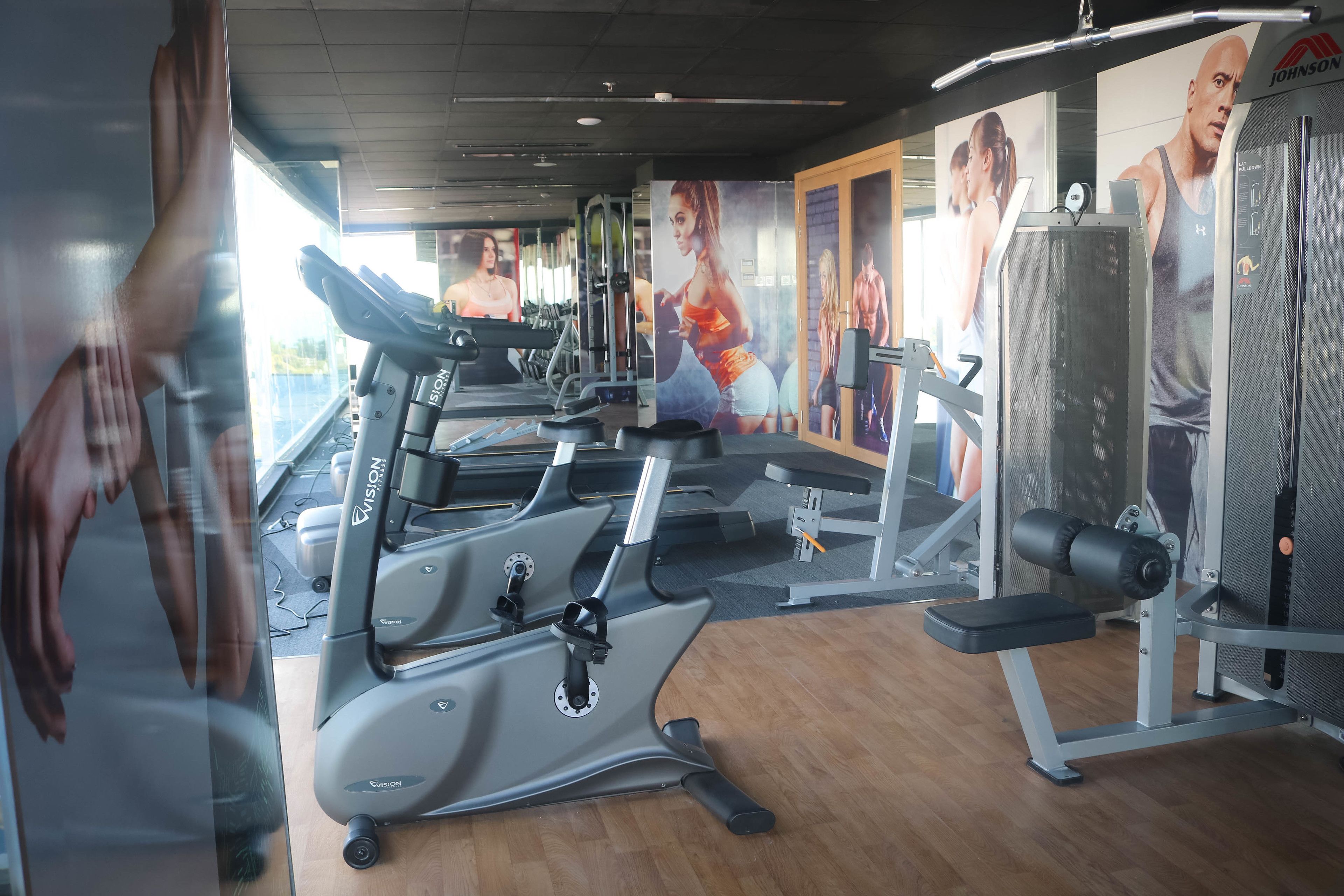 A gym with treadmills, a bench press, and a weight machine.