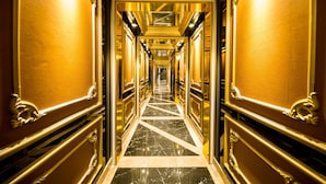 A luxurious hallway with ornate gold detailing and a reflective floor. - Quinter Central Nha Trang (Nha Trang)