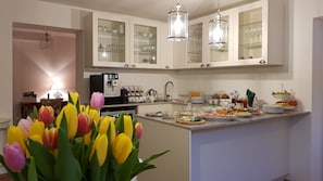 A modern kitchen with white cabinets, a coffee machine, and a breakfast bar.