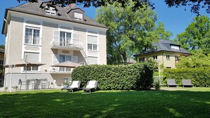 Un edificio grande de dos pisos con un balcón y un área de estar al aire libre.