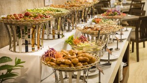 Una mesa de buffet con diversos alimentos y utensilios para servir.