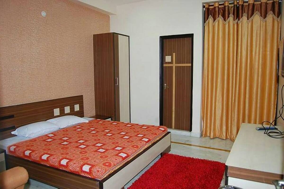 A bedroom with a bed, wardrobe, and curtains.