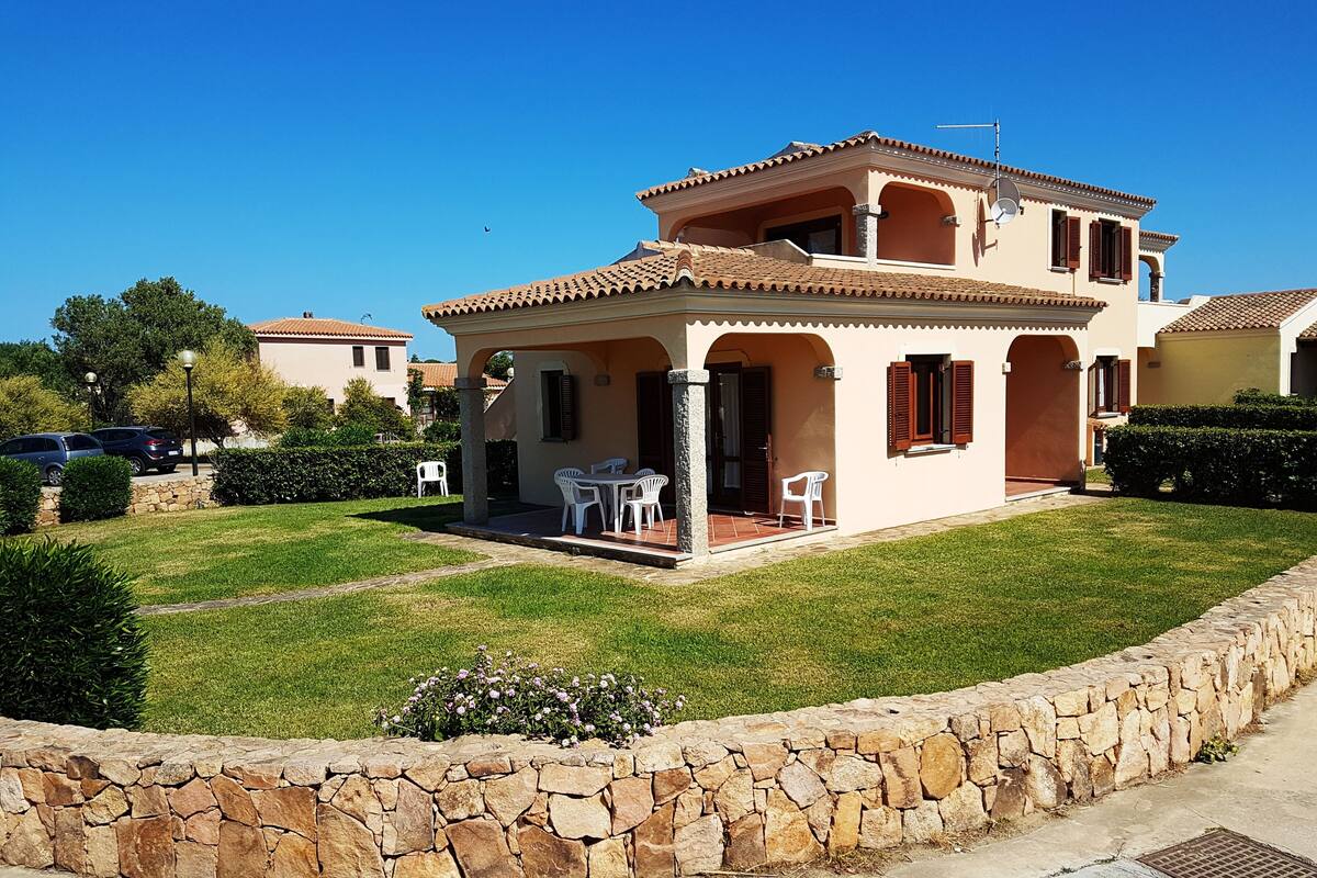 A two-story house with a patio and outdoor seating area.
