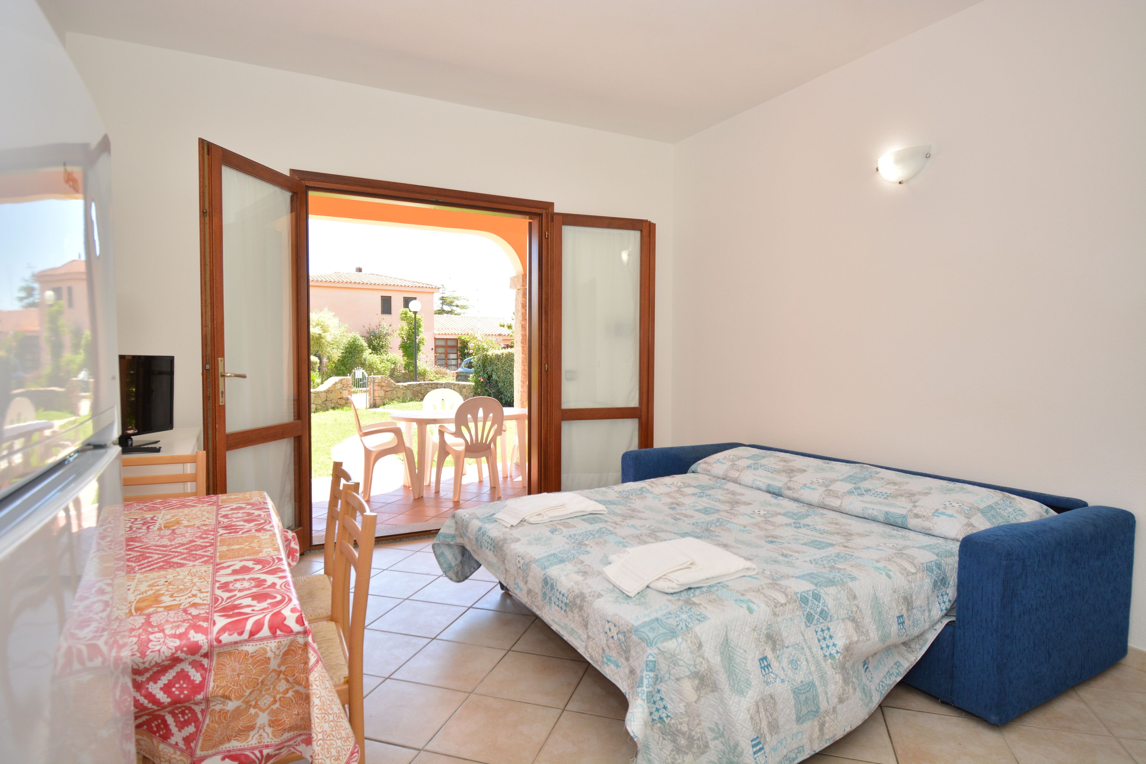 A bedroom with a bed, a table, and chairs.