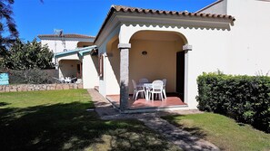 A two-story house with a patio area featuring a table and chairs.