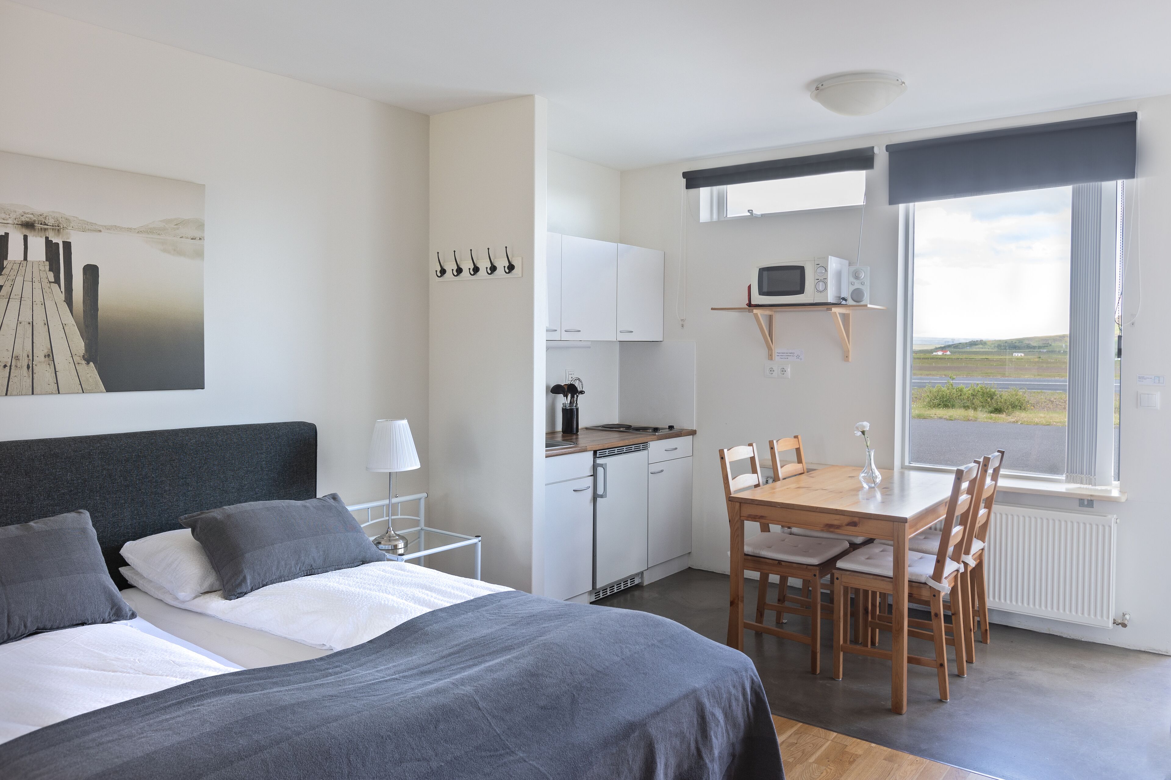 A bedroom with a bed, bedside table, and a view of a dock.