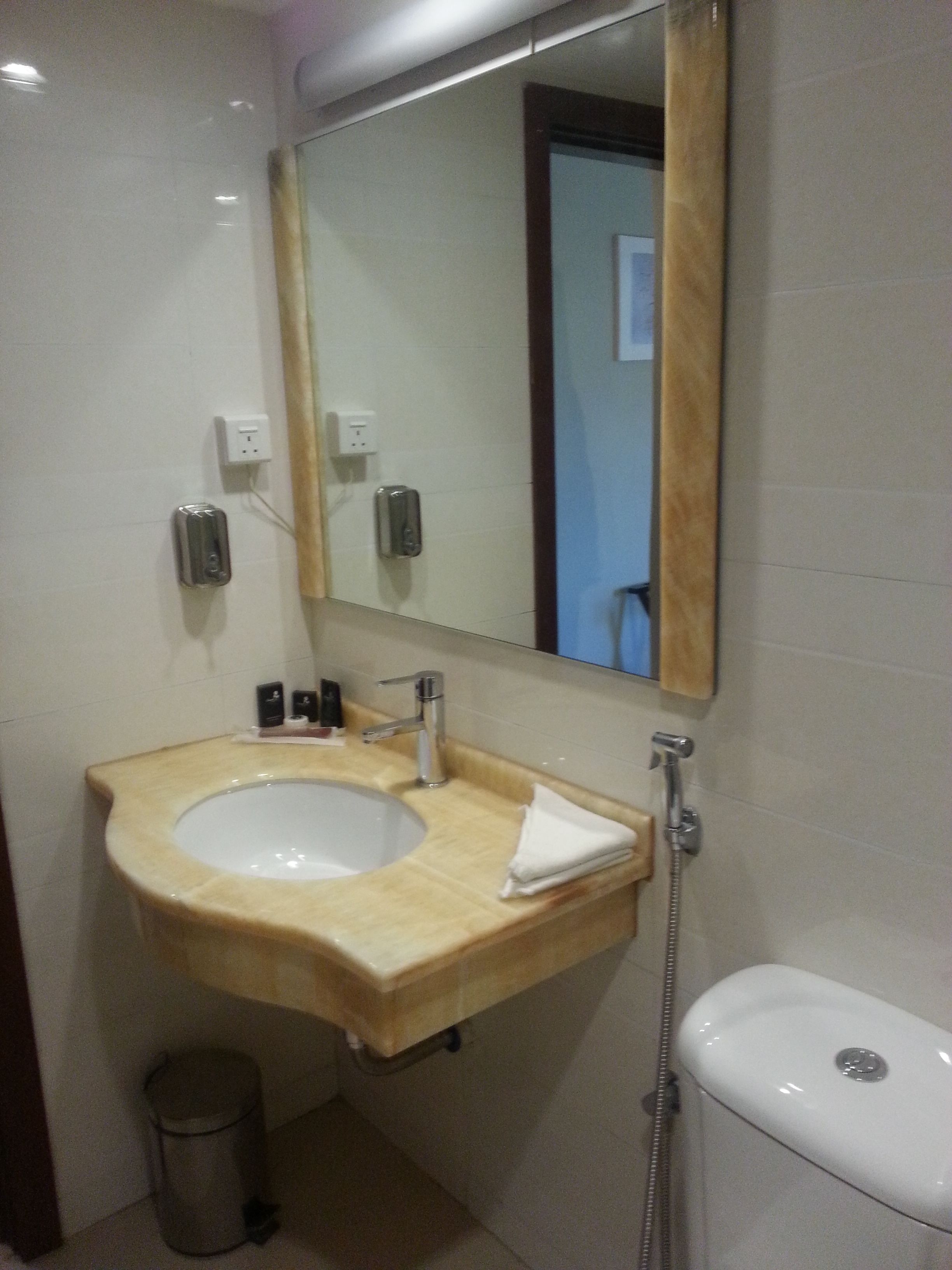 A bathroom with a sink, mirror, and toilet.