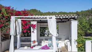 A white outdoor bedroom with a canopy, a bed, a chair, and a small table. - Agroturismo Can Cosmi Prats (Santa Eulalia del Rio)