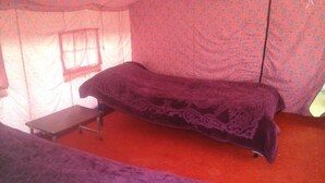 A room with a bed, a small table, and a window. - Lotus Camp and Restaurant (Leh)