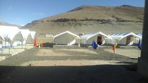 A row of white tents with a mountainous backdrop. - Lotus Camp and Restaurant (Leh)