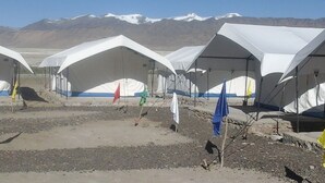A row of white tents with blue trim, set against a mountainous backdrop. - Lotus Camp and Restaurant (Leh)